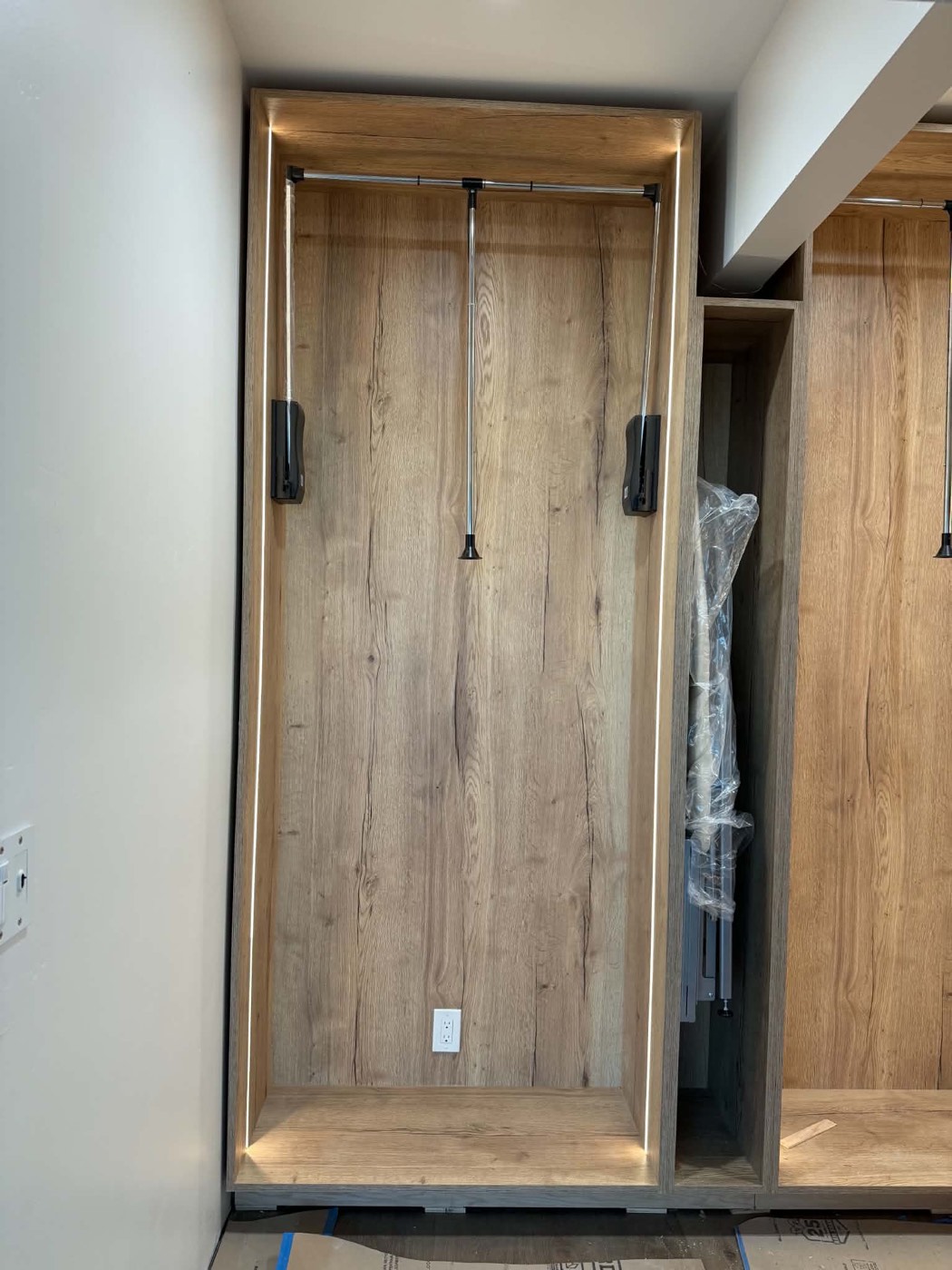 Custom built-in closet cabinetry with LED lighting and telescoping rods