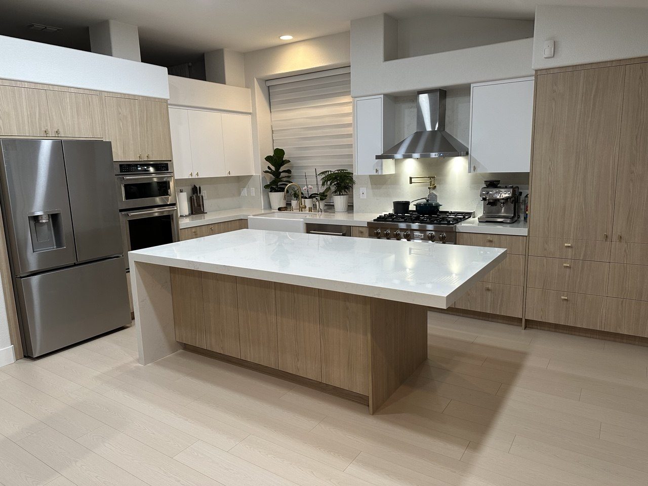 Modern kitchen remodel with white oak cabinetry and waterfall island